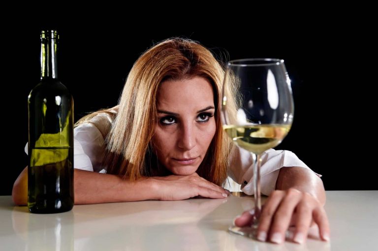 woman looking at wine glass as a high functioning alcoholic